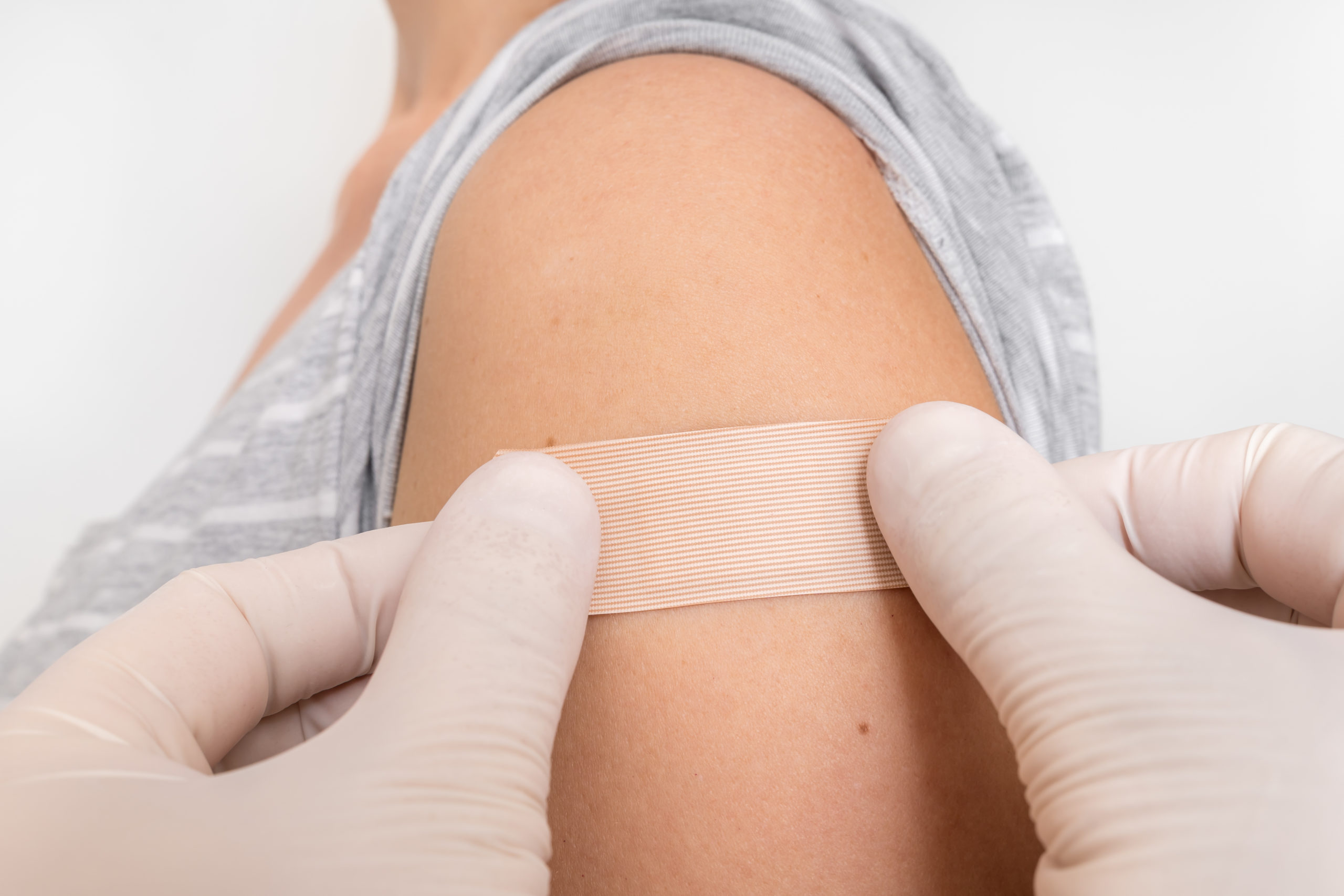 Woman with adhesive bandage on her shoulder