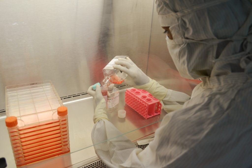 Person in a hazmat suit working in a laboratory setting